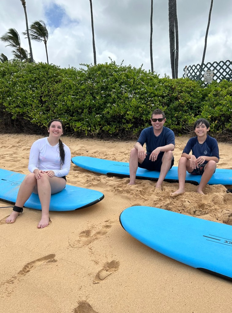 Chris Barry of Chris Barry Voiceover with his son and daughter sitting on surfboards.